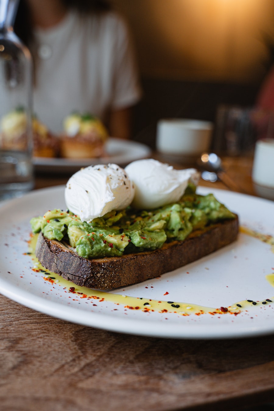 Avocado toast topped with a poached egg on dark bread