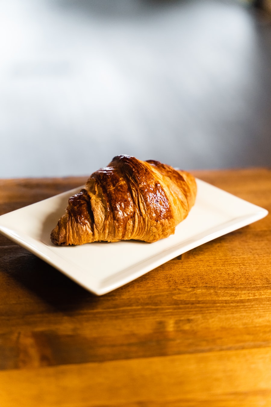 A golden butter croissant on a white plate