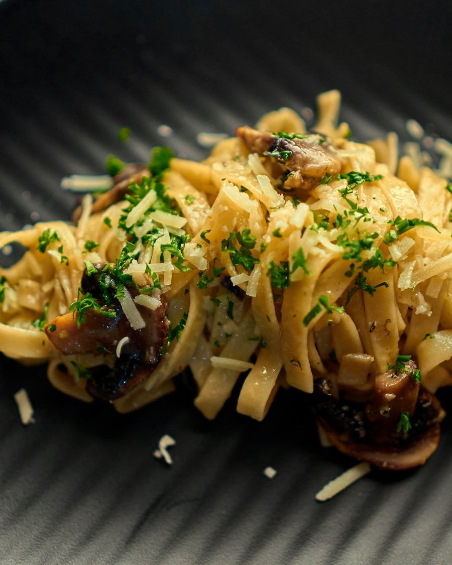 Tagliatelle with shaved winter truffle and aged parmesan, close up under low light
