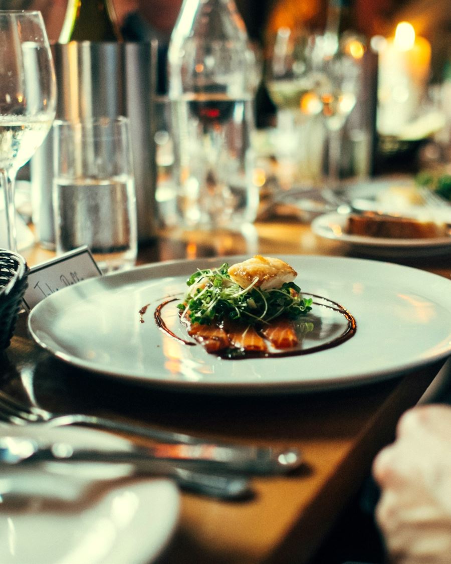 A laid table mid-service, plates and glasses under warm light
